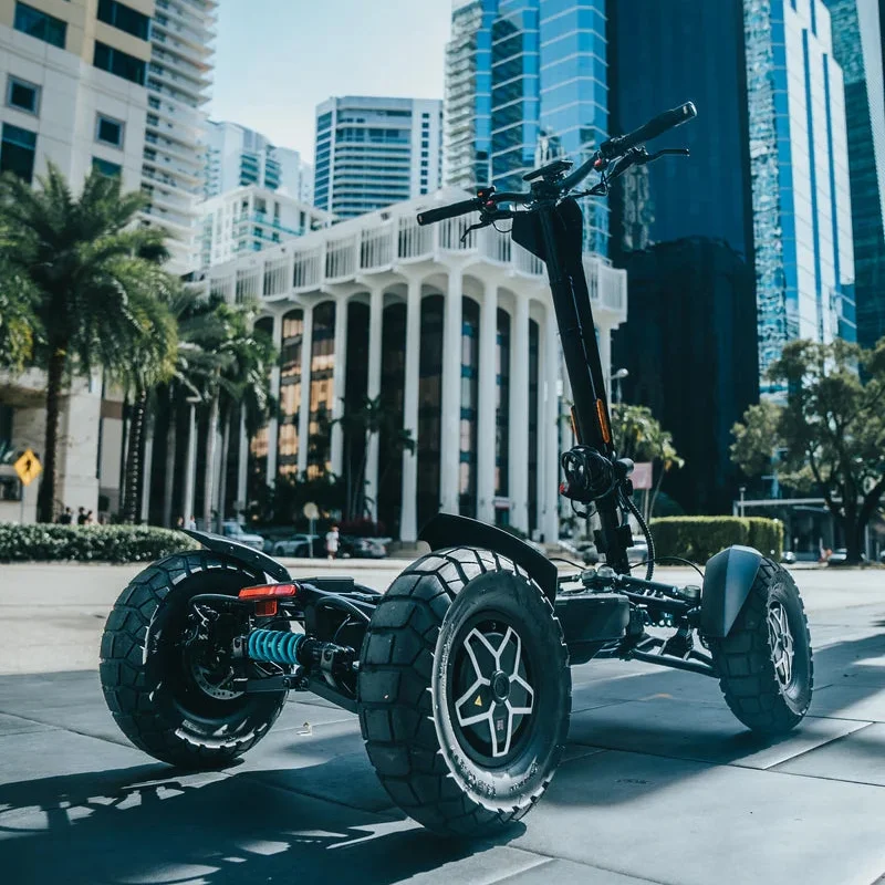 Low angle shot of the MIA Four X2 scooter parked in the city with tall modern buildings in the background
