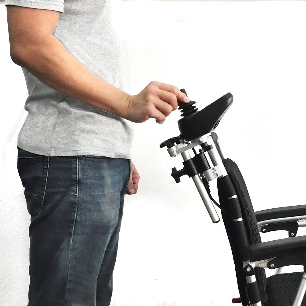 Porto Mobility Ranger Quattro XL folding power wheelchair, person standing beside the chair using the raised joystick