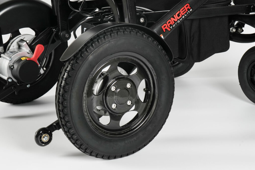 Porto Mobility Ranger TorqueLite folding power wheelchair, rear wheel and anti tip wheel close up